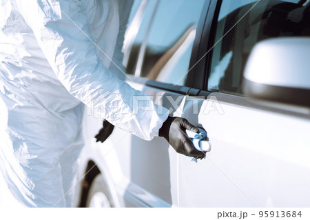Hand of Man in protective suit washing and disinfection handles of a car.Pandemic in quarantine city 95913684