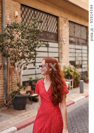 Beautiful young girl wearing sunglasses sightseeing town 95914594