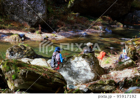 川で休憩する登山家 95917192