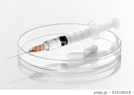 Syringe with liquid transparent vaccine for injection and white pills on petri dish in laboratory white background- biochemistry- molecular biology- genetics and clinical concept 95919038