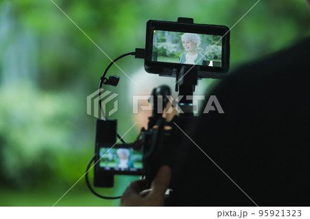 シニア女性の映像を撮影するカメラマン シニア女性の映像を撮影するカメラマン 95921323