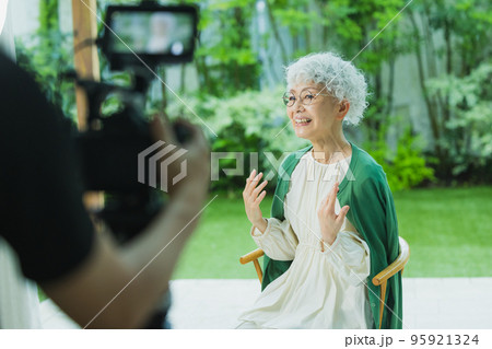 シニア女性の映像を撮影するカメラマン 95921324