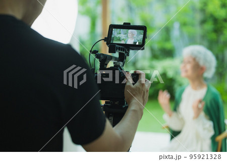 シニア女性の映像を撮影するカメラマン 95921328