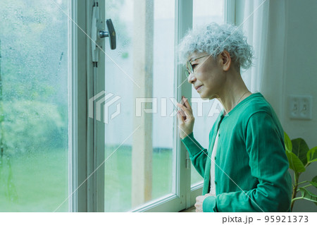 雨の窓辺のシニア女性 雨の窓辺のシニア女性 95921373