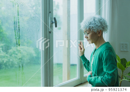 雨の窓辺のシニア女性 雨の窓辺のシニア女性 95921374
