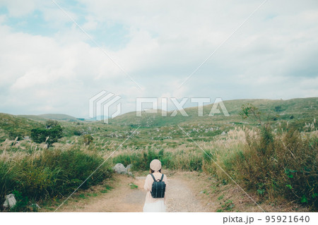 自然の中にカメラを持って佇む女性の写真 95921640