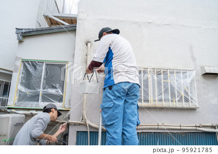 建物の外壁に塗装をする職人 95921785