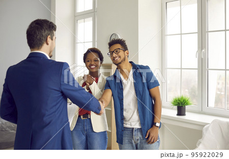 Real estate agent handshake couple buyers Real estate agent handshake couple buyers 95922029