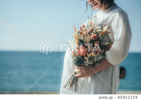 海辺でブーケを持つ妊婦さん 海辺でブーケを持つ妊婦さん 95922259