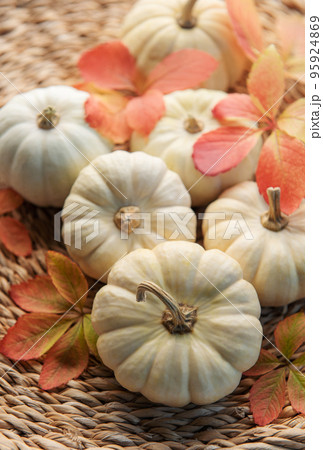 Autumn leaves and pumpkins over wicker mat background Autumn leaves and pumpkins over wicker mat background 95924869