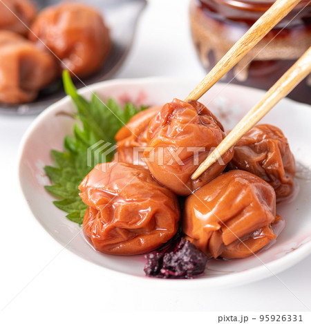 大粒の酸っぱい梅干し （ しそ漬け 紀州南高梅 ）箸でつまむ 95926331