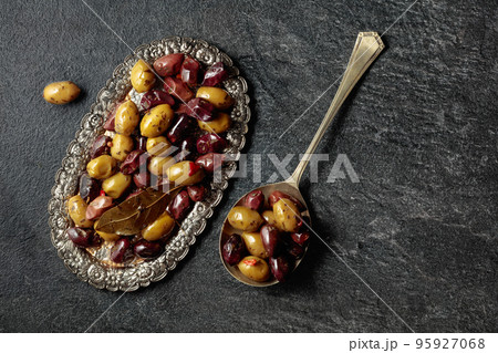 Spicy olives on a black stone table. 95927068