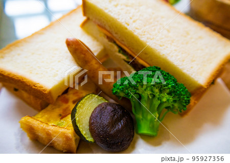 日差しが降り注ぐ爽やかなダイニングでサンドイッチとキッシュ、野菜のワンプレート朝食のアップ(千葉県) 日差しが降り注ぐ爽やかなダイニングでサンドイッチとキッシュ、野菜のワンプレート朝食のアップ(千葉県) 95927356