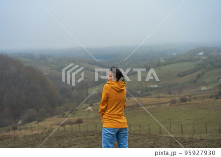 The girl walks in a meadow high in the mountains. Spectacular views of the valley of the clouds The girl walks in a meadow high in the mountains. Spectacular views of the valley of the clouds 95927930