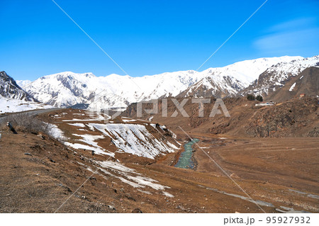 A mountain river with clear icy water flows through a mountain deer in early spring A mountain river with clear icy water flows through a mountain deer in early spring 95927932