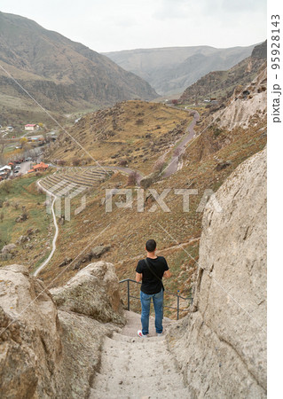 The guy the tourist walks between the stones exploring the ancient city in the rock 95928143