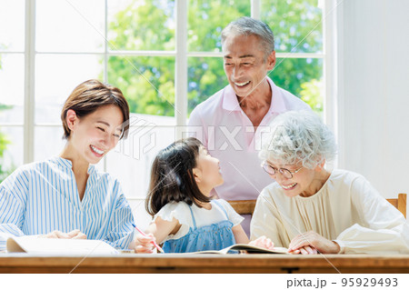 自宅で勉強する小学生を見守る家族 95929493