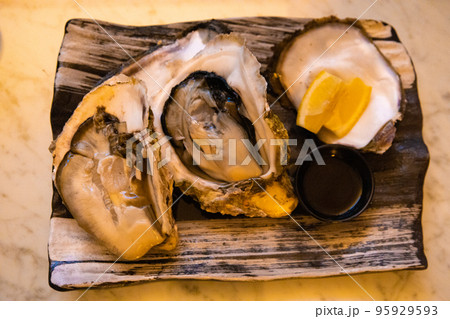 ディナー・夕食の和皿に乗った千葉産の大きな生牡蠣の刺身とポン酢とレモン（千葉県） 95929593