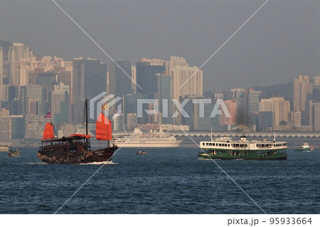 ホンコンのビクトリア湾を航行するスターフェリー。左は観光船「アクアルナ」 95933664