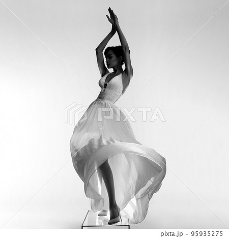 Beautiful young lady posing in a photo studio in a chic dress. S 95935275
