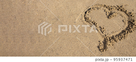 A heart drawn in the sand. Beach background. Top view, space for text A heart drawn in the sand. Beach background. Top view, space for text 95937471