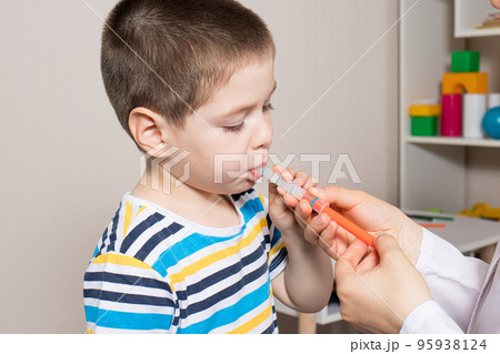 The pediatrician or nurse gives the child syrup in a measuring syringe. Treatment of cough, temperature in children. Paracetamol or ibuprofen for toddlers and preschoolers in pediatrics The pediatrician or nurse gives the child syrup in a measuring syringe. Treatment of cough, temperature in children. Paracetamol or ibuprofen for toddlers and preschoolers in pediatrics 95938124