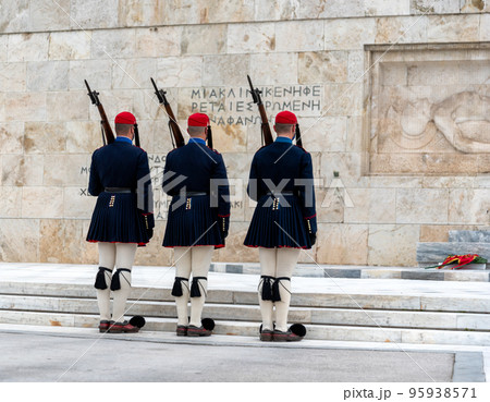 text on the wall "And one bed remains empty for the unknown" in Greek and Greek Evzone soldiers in traditional costumes text on the wall "And one bed remains empty for the unknown" in Greek and Greek Evzone soldiers in traditional costumes 95938571