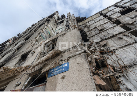 plate text in Ukrainian "safe house" on the wall of a destroyed and burned house in Ukraine 95940089