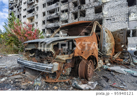 burnt blown up car against the background of a destroyed house in Ukraine burnt blown up car against the background of a destroyed house in Ukraine 95940121