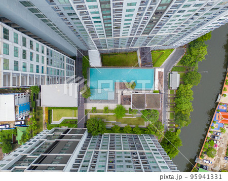 Aerial view of a condominium with swimming pool and sky garden. Top of high rise residential architecture building in urban city, Bangkok Downtown, Thailand. 95941331