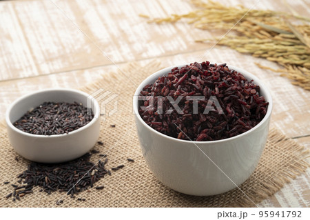 Cooked brown rice or riceberry rice in white bowl on wood table Cooked brown rice or riceberry rice in white bowl on wood table 95941792