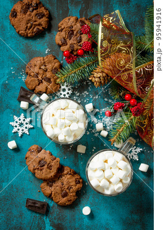 Hot Chocolate with Marshmallows and Homemade Chocolate Chip Cookies on a blue stone or concrete table. Top view flat lay background. Hot Chocolate with Marshmallows and Homemade Chocolate Chip Cookies on a blue stone or concrete table. Top view flat lay background. 95941916