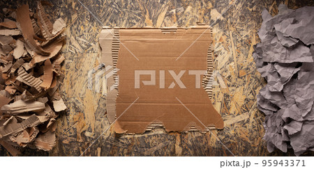 Cardboard torn edge and brown ripped paper on chipboard plywood background. Recycling concept Cardboard torn edge and brown ripped paper on chipboard plywood background. Recycling concept 95943371