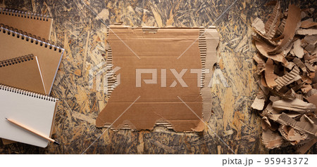 Cardboard torn edge and brown ripped paper on chipboard plywood background. Recycling concept Cardboard torn edge and brown ripped paper on chipboard plywood background. Recycling concept 95943372