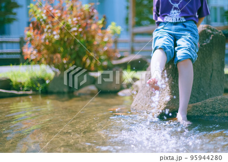 残暑厳しい公園で涼を求めて水遊びする元気な女子 95944280