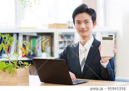 電卓を持つビジネスマン 電卓を持つビジネスマン 95945356