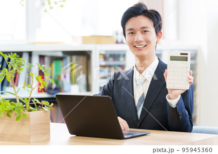 電卓を持つビジネスマン 電卓を持つビジネスマン 95945360