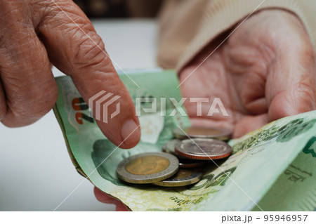 Retired elderly woman counting coins money and worry about monthly expenses and treatment fee payment. 95946957