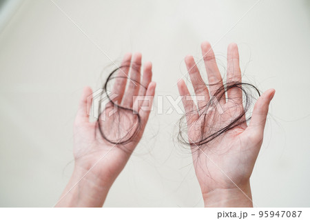 Asian woman have problem with long hair loss attach in her hand. 95947087