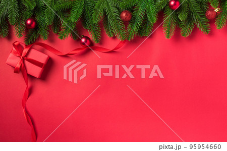 Christmas holiday background with gift box decorations composition, Top view fir green fir tree branches and Xmas ornaments on a red table background Christmas holiday background with gift box decorations composition, Top view fir green fir tree branches and Xmas ornaments on a red table background 95954660