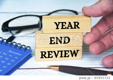 Year end review text on wooden blocks with December calendar, glasses and pen. Accounting and year end review concept. Year end review text on wooden blocks with December calendar, glasses and pen. Accounting and year end review concept. 95955723