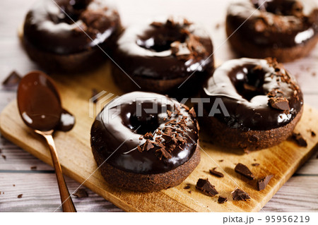 Chocolate donuts on wooden table background. Chocolate donuts on wooden table background. 95956219