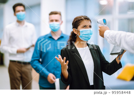 Office staff undergo temperature screening at the entrance. Business People back at work in office. 95958448