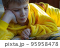 boy lying in bed with a book. child reading home education 95958478
