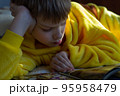 boy lying in bed with a book. child reading home education 95958479