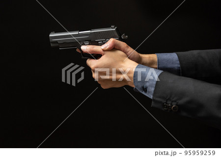 拳銃を構えるスーツ姿の人物 95959259