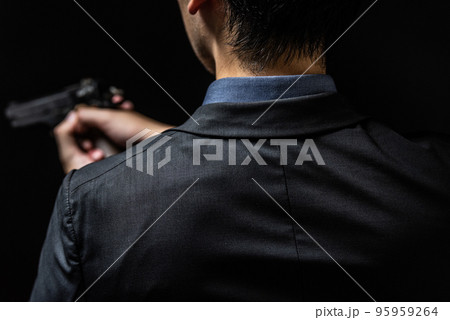 拳銃を構えるスーツ姿の人物 95959264