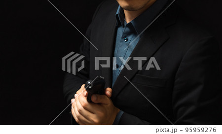 拳銃を構えるスーツ姿の人物 95959276
