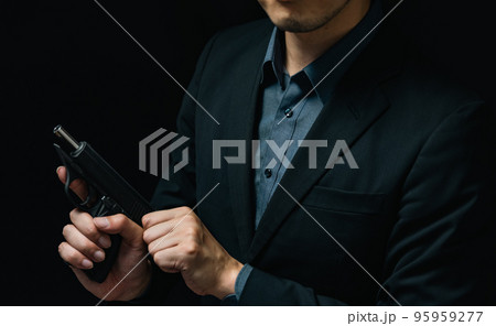 拳銃を構えるスーツ姿の人物 95959277
