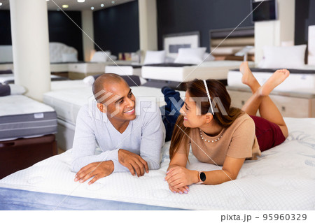 Man and woman choosing mattress in store trying it 95960329